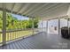Large, covered back porch with views of the private backyard surrounded by mature trees at 127 Charlotte St, Mooresville, NC 28115
