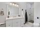 Bright bathroom with white marble vanity, walk-in shower with gray and white tiling and a tile floor at 127 Charlotte St, Mooresville, NC 28115