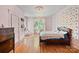 Airy bedroom with hardwood floors and a cozy bed, illuminated by a decorative chandelier at 127 Charlotte St, Mooresville, NC 28115