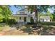 Charming two-story white home with a covered front porch and a well-maintained lawn and mature trees at 127 Charlotte St, Mooresville, NC 28115