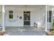Charming front porch with classic columns, gray wood flooring, and a vintage mailbox at 127 Charlotte St, Mooresville, NC 28115