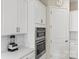 Bright kitchen features white cabinets, stainless steel double ovens and neutral countertops at 197 Tetcott St, Mooresville, NC 28115