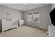 Cozy bedroom with a crib, dresser, carpet flooring, and natural lighting at 197 Tetcott St, Mooresville, NC 28115