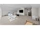 Large bonus room with neutral carpet, TV, and access to doors and stairway at 197 Tetcott St, Mooresville, NC 28115