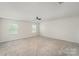 Spacious bedroom featuring plush carpeting, neutral walls, a ceiling fan, and bright, natural light from two windows at 2039 Morning Gold Dr, Maiden, NC 28650