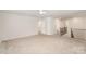 Spacious living room with neutral carpet, stairs with dark wooden railing, and an entrance to the bathroom at 2039 Morning Gold Dr, Maiden, NC 28650