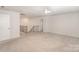 Spacious living room with neutral carpet, stairs with dark wooden railing, and an entrance to another room at 2039 Morning Gold Dr, Maiden, NC 28650