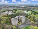 Aerial view of condo complex, complete with lush landscaping, mature trees, and a nearby pond at 211 Heritage Blvd # 301, Fort Mill, SC 29715