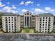 View of a multistory apartment building with a courtyard, balconies, and ample parking on a sunny day at 211 Heritage Blvd # 301, Fort Mill, SC 29715
