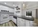 Close up of a modern kitchen with white cabinets, black countertops, subway tile backsplash, and stainless steel sink at 211 Heritage Blvd # 301, Fort Mill, SC 29715