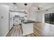 Bright, open living space featuring a modern kitchen with white appliances and an adjacent living room with a ceiling fan at 211 Heritage Blvd # 301, Fort Mill, SC 29715