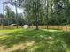 Large, fenced backyard featuring a new wooden fence, mature trees, and shed at 166 Brook Creek Dr, Troutman, NC 28166