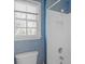 Bathroom with blue wallpaper, including toilet, shower with white tile, and small window at 3109 Savannah Hills Dr, Matthews, NC 28105