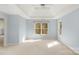 Expansive bedroom with tray ceiling and large windows offering natural light and a serene atmosphere at 3109 Savannah Hills Dr, Matthews, NC 28105