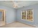 Well-lit bedroom with a ceiling fan and a large window with a view of the yard at 3109 Savannah Hills Dr, Matthews, NC 28105