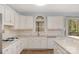 Bright kitchen features white cabinetry, tiled backsplash, and hardwood flooring at 3109 Savannah Hills Dr, Matthews, NC 28105