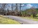 Long driveway to brick house with attached carport surrounded by mature trees at 3407 14Th Sw Ave, Hickory, NC 28602