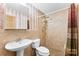 Tiled bathroom featuring a pedestal sink and walk-in shower with curtain at 4107 Windwood Dr, Gastonia, NC 28056