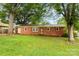 Charming red brick home with mature trees and a well-manicured lawn at 4107 Windwood Dr, Gastonia, NC 28056