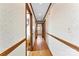 Long hallway with hardwood floors, decorative wallpaper, and wood trim at 4107 Windwood Dr, Gastonia, NC 28056