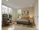 Comfortable bedroom with large windows, a cozy bed with decorative pillows, and a sitting area with a chair at 4969 Fitzgerald Ave, Charlotte, NC 28213