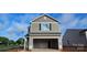 New two-story home featuring an attached garage with neutral siding and black shutters against a bright blue sky at 503 Maddox Dr, Shelby, NC 28152