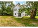 View of the back of the home with sliding glass door, patio, and large backyard at 506 Legrand St, Shelby, NC 28150