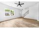 Bright living room featuring light wood floors, a modern ceiling fan, and a large window for ample natural light at 506 Legrand St, Shelby, NC 28150