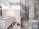 Modern bathroom boasts a frameless glass shower, granite countertops, and stylish gray tile flooring at 605 Allen Way, Indian Trail, NC 28079