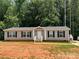 Home's front exterior with gray siding, black shutters, and a well-maintained yard at 185 Crystal Bay Dr, Mooresville, NC 28115