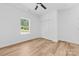 A bright bedroom with wood floors, a ceiling fan, a window with an outside view, and a spacious closet at 2363 Reepsville Rd, Lincolnton, NC 28092