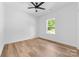 This bedroom features wood floors, a modern ceiling fan, and a window with a view of lush greenery at 2363 Reepsville Rd, Lincolnton, NC 28092