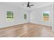 This bright bedroom has wood floors, two windows, a ceiling fan, and natural light at 2363 Reepsville Rd, Lincolnton, NC 28092