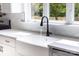 Bright kitchen sink with black faucet, white cabinets, and a view of the outdoors at 2363 Reepsville Rd, Lincolnton, NC 28092