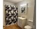A bathroom featuring a floral shower curtain, vanity with storage, and a wall mirror at 301 Louise St, Lancaster, SC 29720