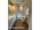 Bright bathroom with a marble-tiled shower-tub, modern vanity with white cabinets, and wood-look flooring at 318 Stanback St, Mount Gilead, NC 27306