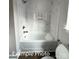 Close-up of bathroom featuring white tub with marble-style tiled shower, bronze fixtures and toilet at 318 Stanback St, Mount Gilead, NC 27306