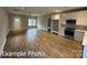 Open-concept living space featuring wood floors and a view of the modern kitchen at 318 Stanback St, Mount Gilead, NC 27306