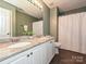 Bathroom with a double sink vanity, granite countertop, and a shower with a white textured shower curtain at 557 S Portman Ln, Fort Mill, SC 29708