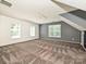 Large bedroom with three windows, white and blue walls, tan carpet, and an interesting ceiling line at 557 S Portman Ln, Fort Mill, SC 29708