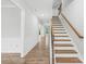 Light and airy hallway featuring wood-look floors, decorative wall panels, and a staircase at 121 Pine Eagle Dr, Rock Hill, SC 29732