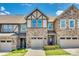 Charming townhome featuring a stone and siding exterior with attached garage under a clear blue sky at 1213 Bhaltair Ln, Fort Mill, SC 29708