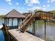 Close-up of a lakefront dock with a covered sitting area, stairs to an upper deck and serene water views at 126 Balmoral Dr, Mooresville, NC 28117