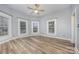 Bright bedroom featuring wood-look floors, ceiling fan and plenty of natural light from three windows at 128 Allenton St, Norwood, NC 28128