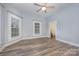 Bright bedroom featuring wood-look floors, ceiling fan and plenty of natural light from multiple windows at 128 Allenton St, Norwood, NC 28128