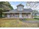 Charming home featuring a covered front porch with detailed supports, offering a cozy and inviting curb appeal at 128 Allenton St, Norwood, NC 28128