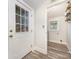 Hallway featuring a white door with window leading outside and access to the laundry room at 128 Allenton St, Norwood, NC 28128