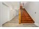 Bright hallway featuring hardwood floors and a staircase with wood details, leading to the upper level at 128 Allenton St, Norwood, NC 28128