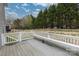 View of wood backyard deck with white bench and railing overlooking the fenced in yard at 1415 Troon Dr, Salisbury, NC 28144