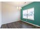 A bright dining room featuring a bold accent wall, wood floors, and a chandelier above at 1415 Troon Dr, Salisbury, NC 28144